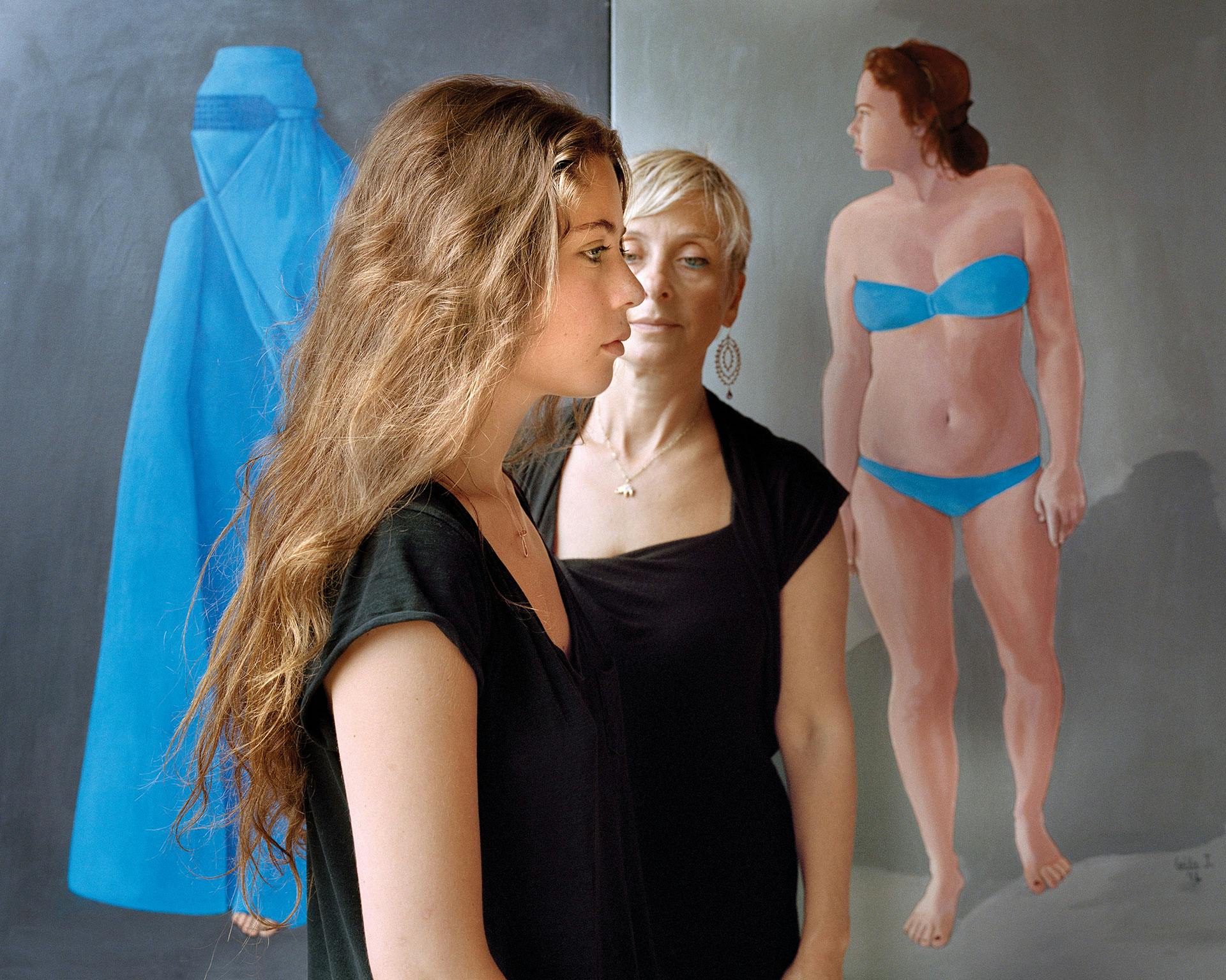 photo of a daughter and mother in front of a painting of a woman in a blue bikini